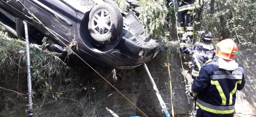 L'auto finisce fuori strada, si ribalta e rimane in bilico su un canale